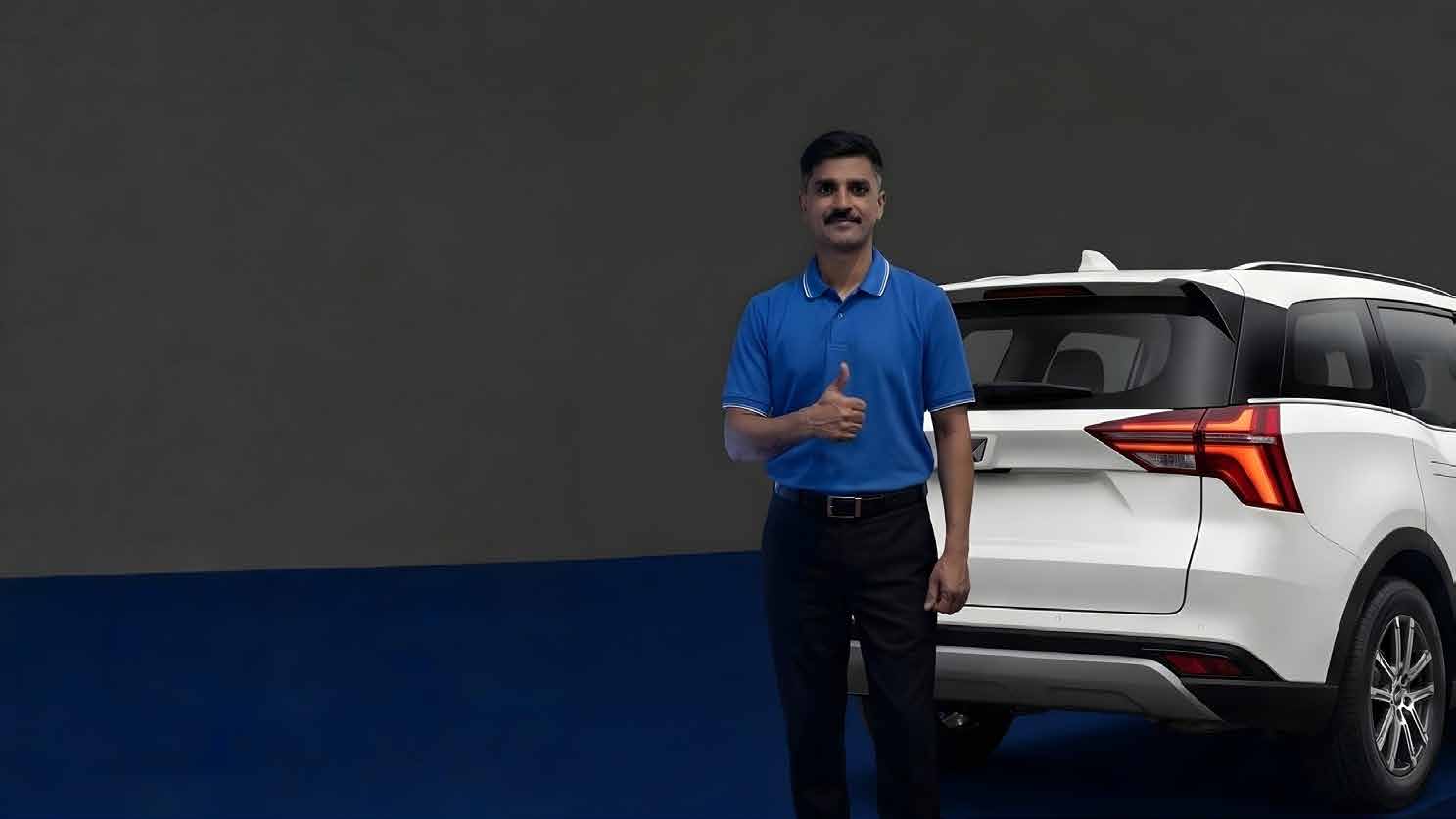 Valeto valet in branded uniform standing beside a client vehicle